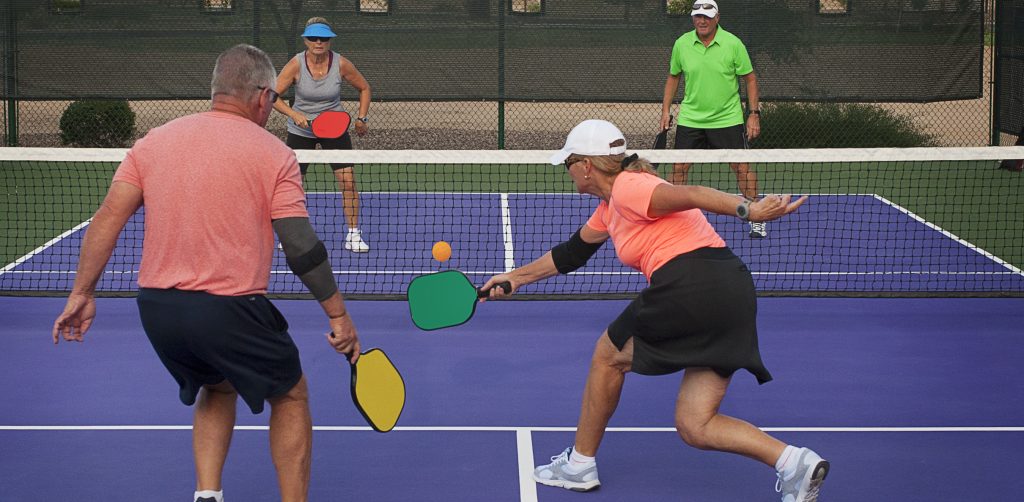 four people playing pickleball e