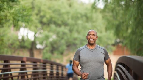 Portrait of a fit mature African American man man jogging over bridge scaled